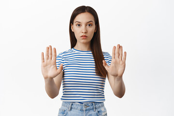 Stop, final warning. Young concerned woman extend hands, stretch out palms in taboo, no block...