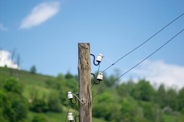Old wooden power pole on a background of blue sky