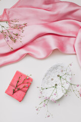 Romantic composition with a pink soap with ceramic dish and silver dress. 