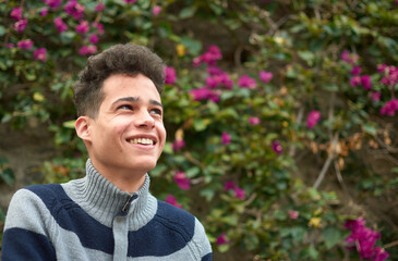 A portrait of a happy Hispanic male in the park