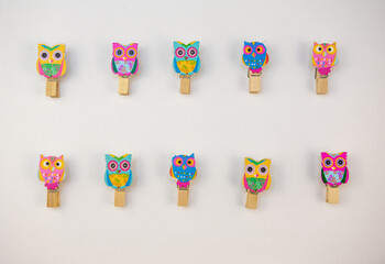 ten wooden owl pegs on a white background