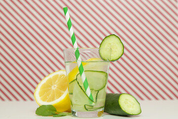 Lemon cucumber water with colorful paper straw. Healthy detox drink.	