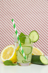 Lemon cucumber water with colorful paper straw. Healthy detox drink.	