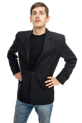 Young handsome tall slim white man with brown hair looks confident with hands on hips in black blazer isolated on white background