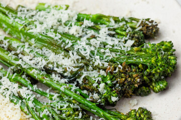 Cooked fresh broccolini with grated cheese and on the plate