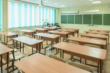 An empty classroom at a school without people with a bouquet of flowers on the teacher's desk