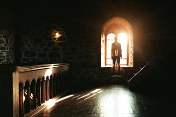 silhouette of a guy standing near the window in a Genoese fortress in Sudak Crimea Stone walls of an ancient castle