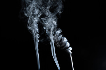 Incense smoke in motion with black background.