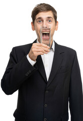 Young handsome tall slim white man with brown hair with glass of water in front of his open mouth isolated on white background