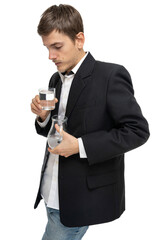 Young handsome tall slim white man with brown hair looking at glass of water and glass pitcher of water isolated on white background