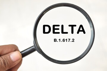 New covid-19 delta variant strain symbol. Man holds a magnifying glass in his hand.
