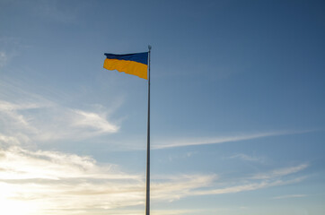 The highest flagpole with Ukrainian flag waving in blue sky in Kyiv, Ukraine