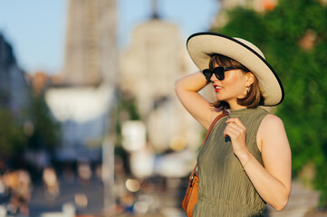 Woman with sunglasses and hat walking in the city