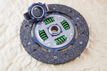 Car spare parts. Car clutch disc and clutch bearing. Photo of a new clutch disc before installation on a car against a background of craft paper.