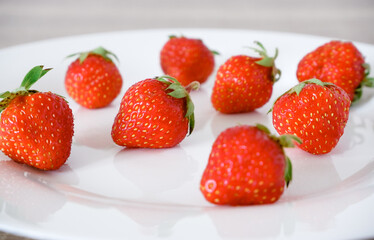 Fresh berries. Fresh juicy red strawberry on a white plate. Close-up photo. Vitamin charge.