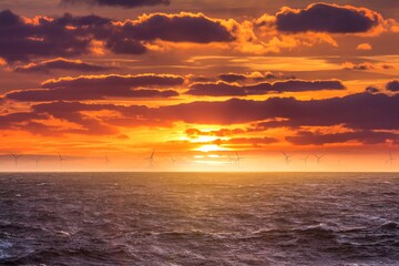 Renewable green electricity wind power generation offshore. Sunrise at decarbonization industry windmills business for regenerative energies. Clean energy renewables preventing climate change - 441461762