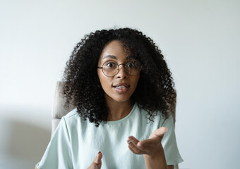 Head shot portrait friendly talking mixed race woman, looking at camera, making video call, recording vlog or webinar