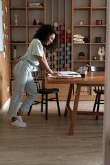 Mixed-race beautiful businesswoman working with papers while standing in modern office