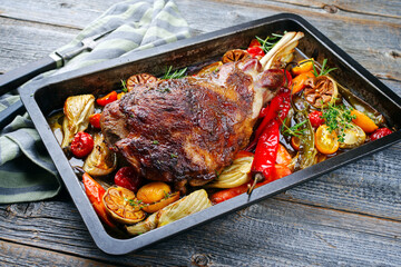 Traditional barbecue lamb shoulder with vegetables and chili served as close-up on a rustic metal...