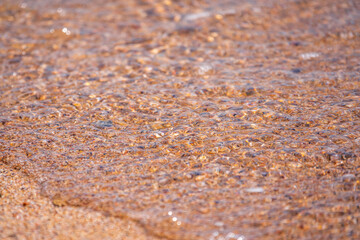 Soft wave of the sea on the sandy beach.