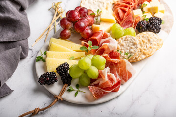 Summer charcuterie board with cheese, meat and fruit