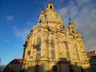 Obraz premium Die Dresdner Frauenkirche in leuchtend sanfter Abendsonne vor blauem Himmel auf Froschperspektive.