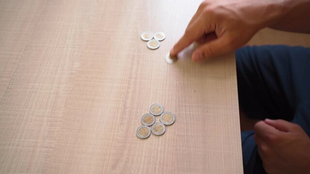 Man Counts Mexican Pesos while Sitting at Home. Poverty and Economic Crisis Concept.