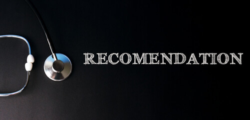 RECOMENDATION written in chalk on a dark background along with a stethoscope. Health care medicine concept. Top view, flat lay.