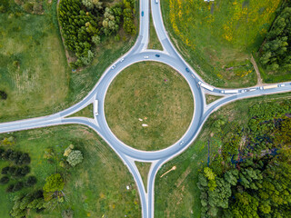 Top down aerial drone view of a small traffic roundabout on a quiet road - obrazy, fototapety, plakaty