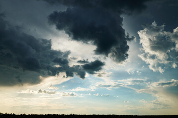 beautiful dark dramatic sky with sunlight and clouds as a background