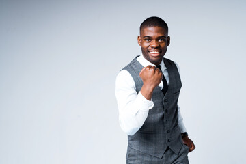 Happy african american businessman rejoices in victory clenching his hand into a fist