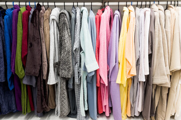 different color bathrobes on the hanger in the shower room, in the store or on the market