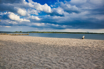 Obraz premium Weitläufiger Sandstrand am Markkleeberger See unter einem dramatischen Wolkenhimmel, Markkleeberg, Sachsen, Deutschland