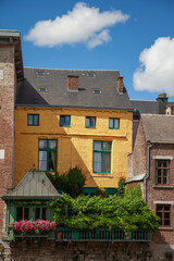 Maison en brique jaune située au centre ville de Namur, Belgique, avec une terrasse avec des arbustes et des fleurs