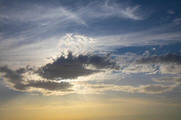 blue sky with clouds and sun rays penetrate the clouds