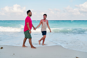 homosexual couple of two men, making a marriage proposal on the coast of cancun beach in the mayan rivera maya mexico, with a turquoise sea in the background.