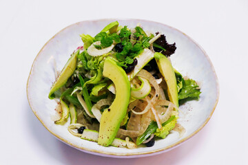 vegetable salad bowl with asparagus, fennel, avocado, raisins and mix lettuce in a bowl