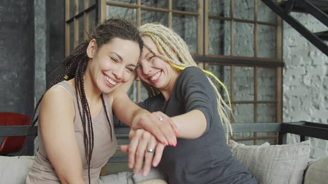 Lesbian couple celebrating their engagement showing the rings