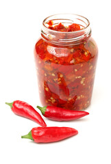 Fototapeta na wymiar Fresh red chilly and bottled chili sauce over white background