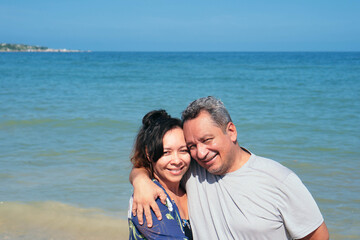 Fototapeta na wymiar Older couple embracing on a beach