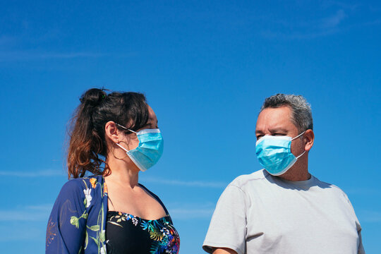 Mature couple with protective mask at the beach