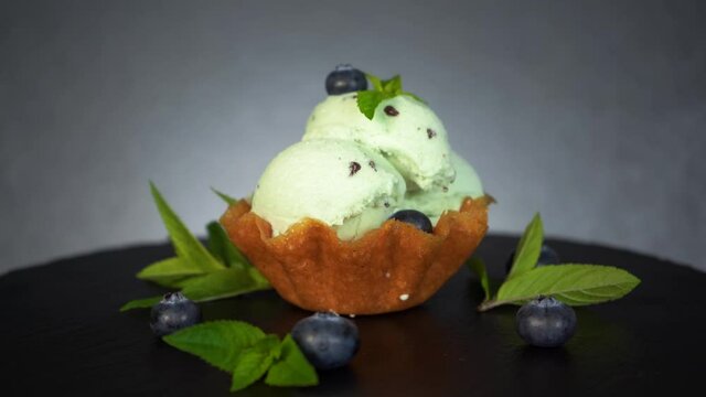 Melting mint ice cream chocolate bites blueberry decorated dessert waffle, 4K
