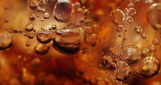 Close-Up of a Sweet Fizzy Drink with Ice. Ice Crystals in Soda. Sweet Carbonated Drink. Gas Bubbles. Amber Water.