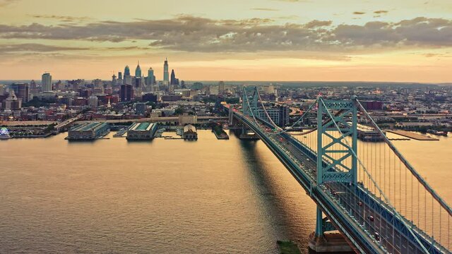Aerial view Ben Franklin Bridge and Philadelphia skyline with smooth forward motion towards the city, at sunset. Ben Franklin Bridge is a suspension bridge connecting Philadelphia and Camden, NJ.