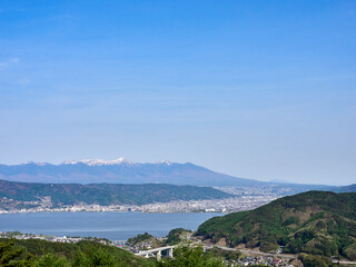 Fototapeta na wymiar 5月上旬、岡谷市の塩嶺王城パークライン展望広場から八ヶ岳・諏訪湖を望む