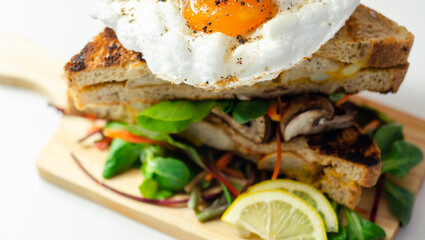 Egg in a cloud on grilled sandwiches with cumberland sausage, tomato and mayonnaise, all served with a fresh salad