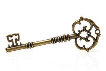 old brass key against a white background
