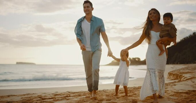 Happy young family playing at the beach at sunset, family time together, beautiful beach vacation, family lifestyle