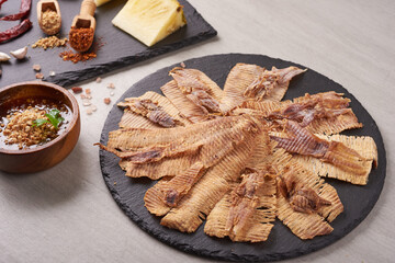 Grilled dried squid with sweet and sour sauce, Grilled dried squid with herbs and spices, various vegetables stone background, Mashed squid is materials raw from the sea, street food. Top view.