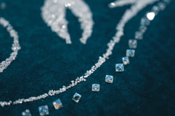Several large diamonds lie on the turquoise velvet. Close-up photo. Cut diamond